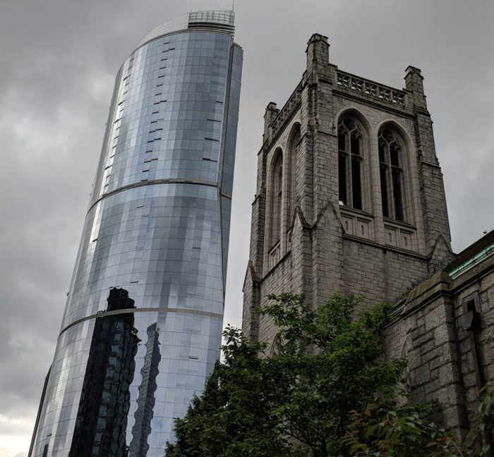 Church tower and shiny hotel