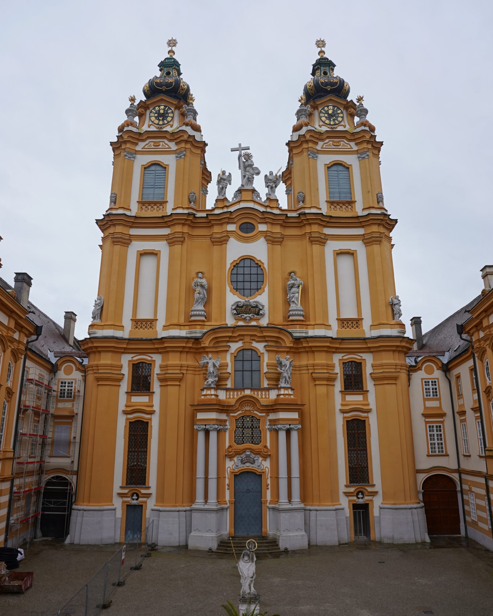 Front of the Melk Abbey church, an elaborately decorated building in orange and white