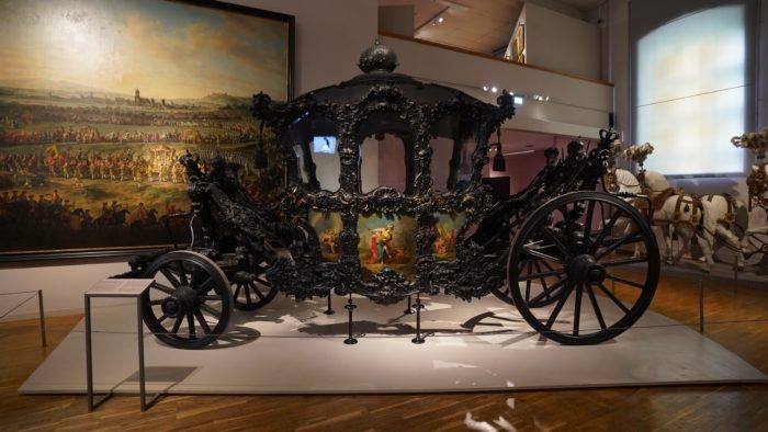 State Coach of the Vienna Court: an elaborately decorated 4-wheel coach painted all in black, except for a few panels on the doors