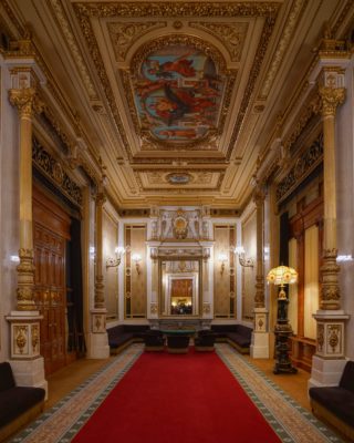 The Tea Room, a gorgeously decorated salon with red carpet, gold decorations, and mirrors