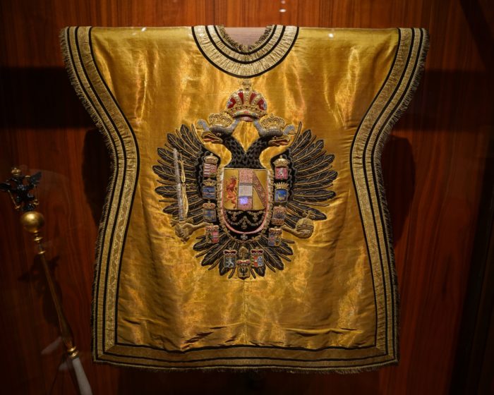 A golden vest with the Austro-Hungarian coat of arms: a double-headed black eagle surrounded by crowns and smaller coats of arms