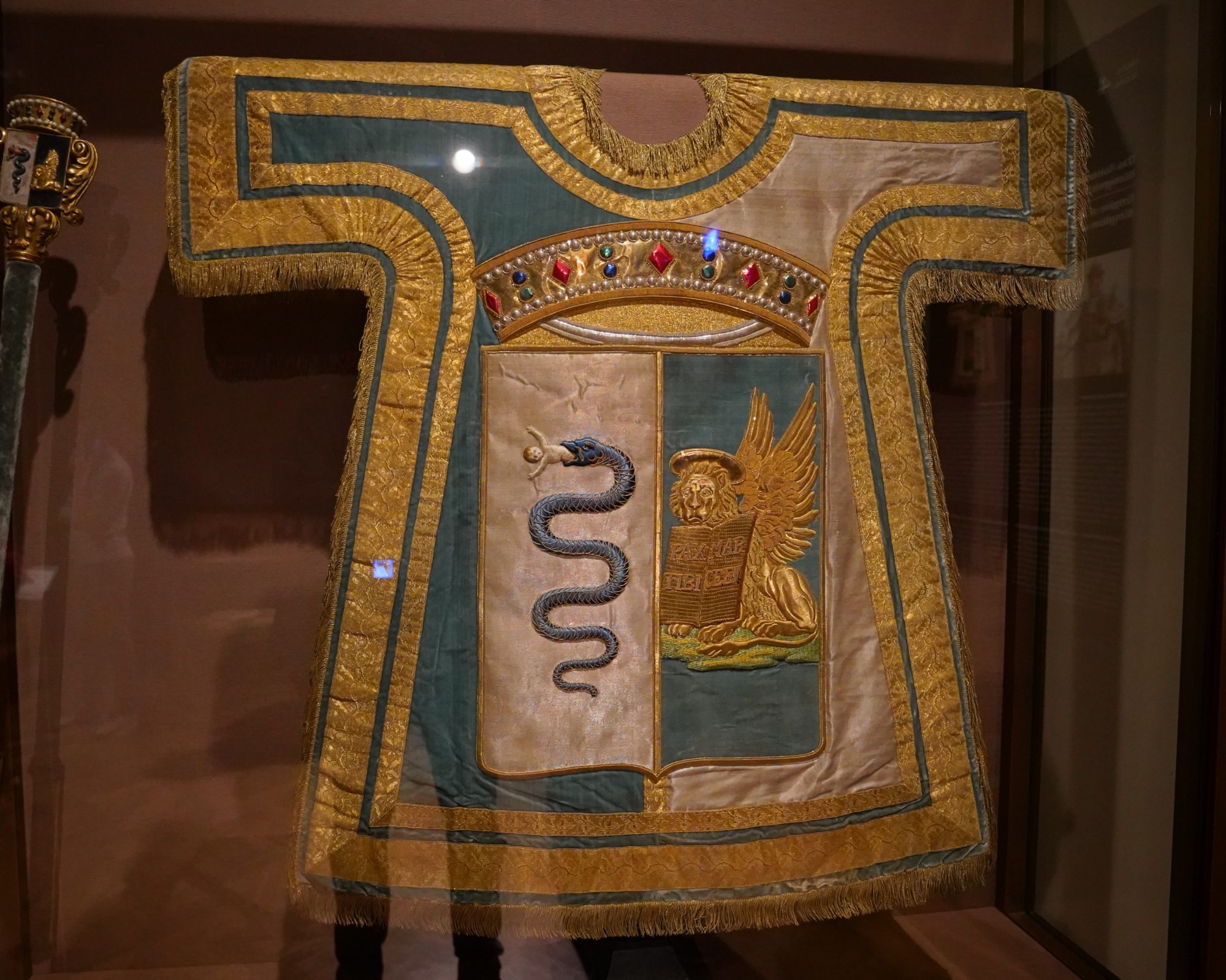 Herald's tabard, a golden vest with the coat of arms of Lombardy-Venetia: a snake on the left and a golden sphinx kind of thing on the right