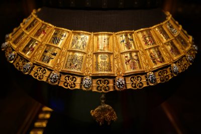 A golden chain / necklace decorated with various coats of arms