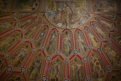 A closeup of a piece of clothing, richly embroidered, covered with images of saints