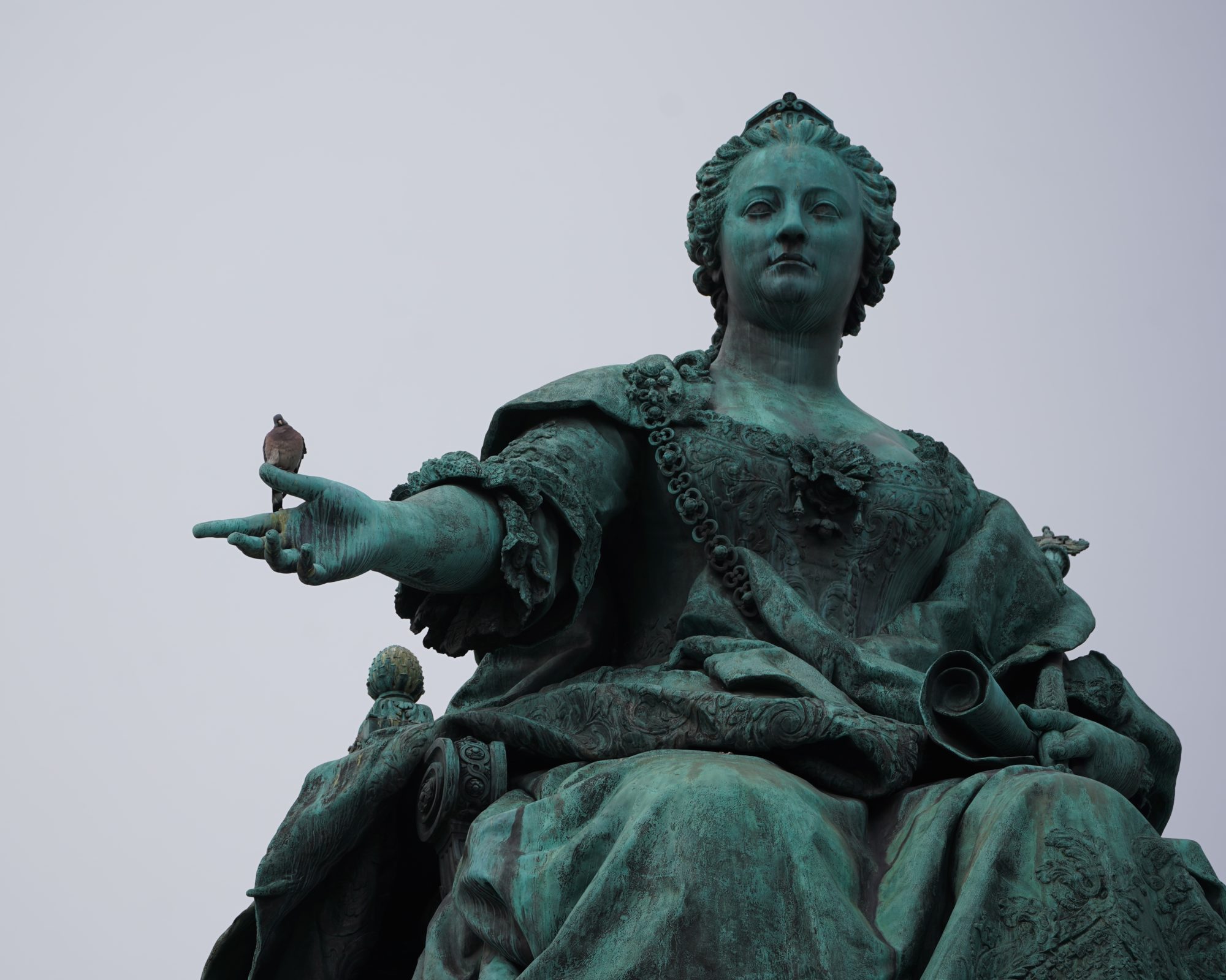 Large bronze statue of Empress Maria Theresa looming over me. A pigeon is sitting on her outstretched hand