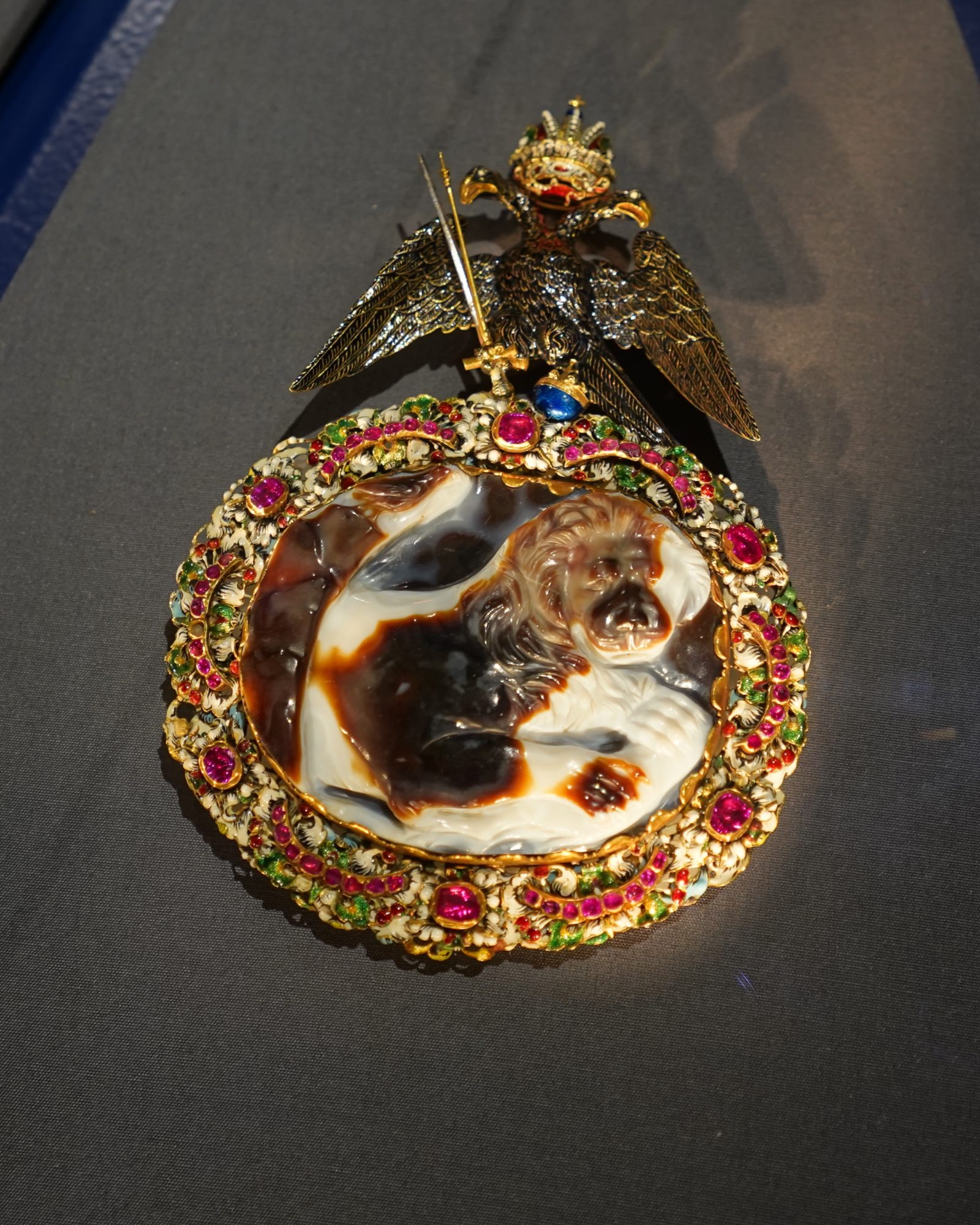 A cameo carved like a lion, in black, red and white, surrounded by a ring of gold and gems, with an imperial eagle on one side