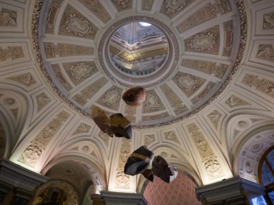 A cupola or dome, open in the centre so we can see a little of the ceiling above. Some stones are suspended in mid air