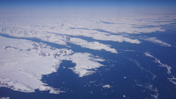 Some deep parallel fjords in a snow-covered land; the right side of the image is dark blue ice
