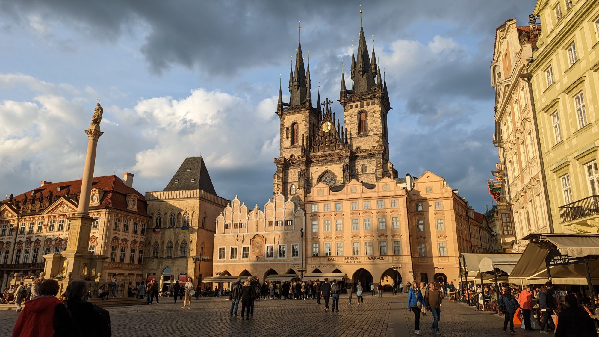The Church of Our Lady Before Týn, from the Old Town Square. The light is low and golden, and there are a few dark clouds in the sky
