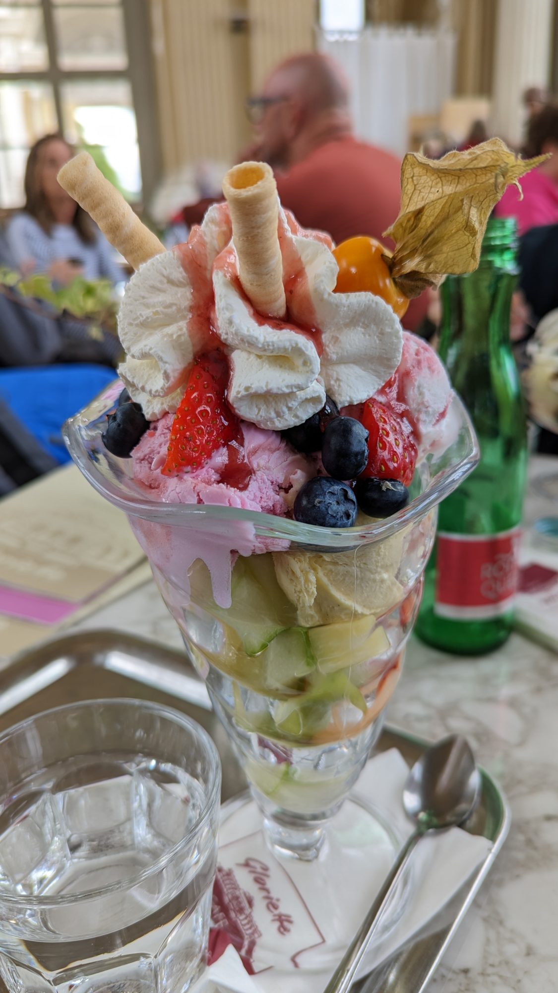 A sundae cup with different flavours and fruit pieces