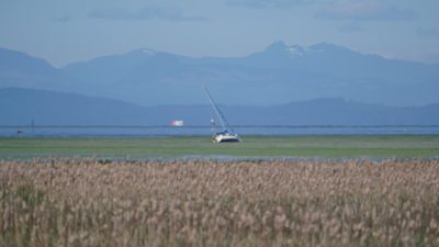 A beached sailboat far out on the marshes