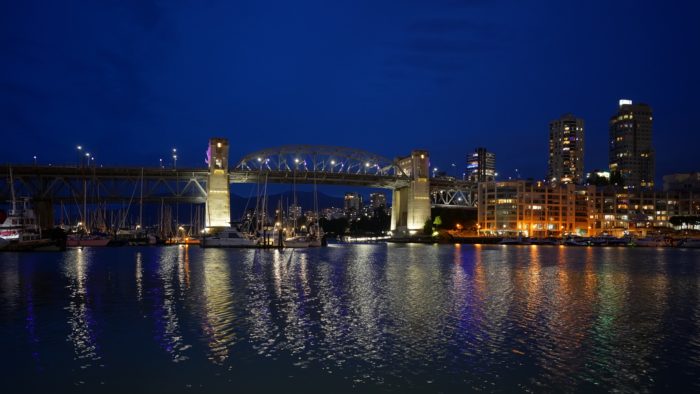 Burrard Bridge at twilight, with city lights reflected in the water