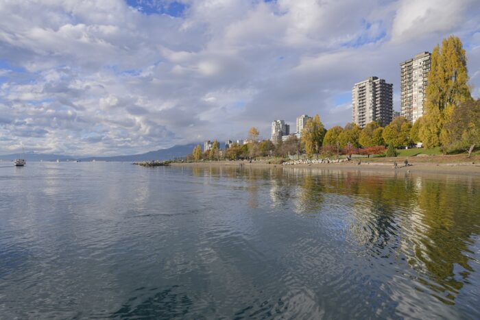 View of West End towers, brightly lit by the sun. The sky is full of little choppy clouds, reflected in the water